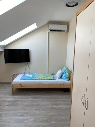 a bedroom with a bed and a tv in a room at Kiskakas Étterem in Zalaegerszeg