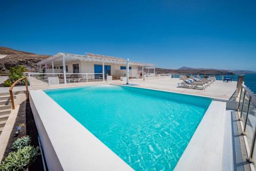 a villa with a swimming pool and the ocean at Etti Paradise - Suite Oceano in Pájara