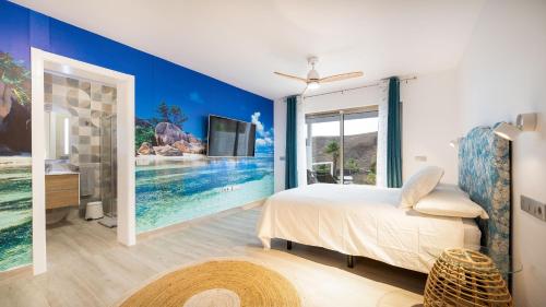 a bedroom with a bed and a tv on a wall at Etti Paradise - Suite Oceano in Pájara