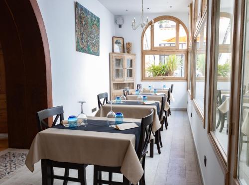 a room with a table, chairs, and a large window at Sa Voga Hotel & Spa in Arenys de Mar