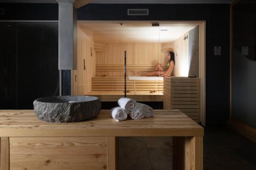 a woman is sitting in a tub in a room at Hotel Li Anta Rossa in Livigno