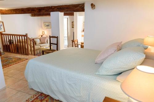 een slaapkamer met een groot bed met kussens erop bij La petite Provence in Bormes-les-Mimosas