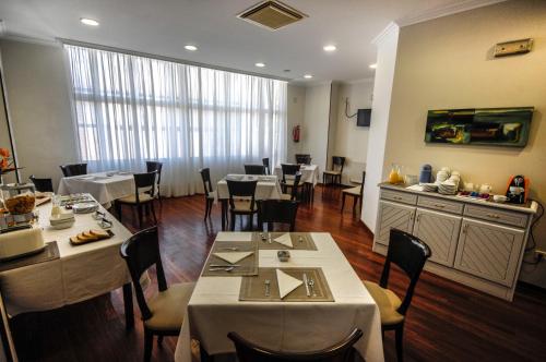 um restaurante com mesas e cadeiras num quarto em Hotel Vigo Plaza em Vigo