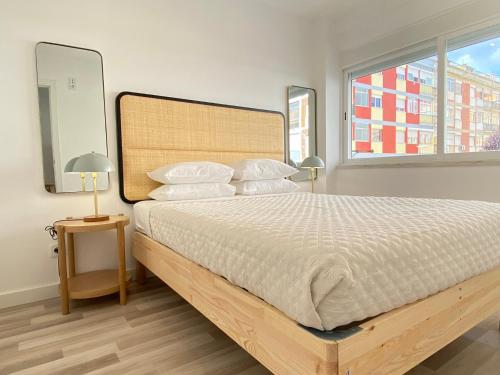 - une chambre avec un grand lit et une grande fenêtre dans l'établissement Project Montalvão, à Setúbal