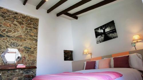 a bedroom with a bed and a stone wall at Casona Granado in El Pilar y Provincias