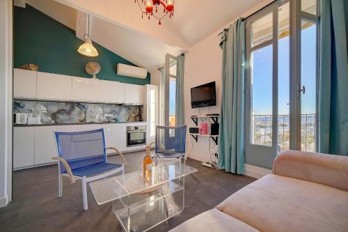 - un salon avec une table en verre et des chaises bleues dans l'établissement EXCEPTIONNEL 3 PIECES AVEC TERRASSE VUE SUR VIEUX PORT CENTRE VILLE l! A2B195, à Cannes