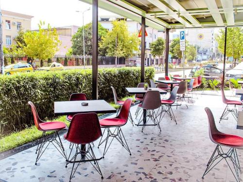 un grupo de mesas y sillas en un restaurante en Iliria Boutique Hotel, en Tirana