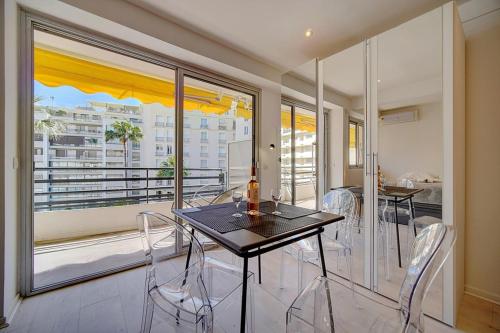 une salle à manger avec une table et des chaises et une grande fenêtre dans l'établissement STUDIO MODERNE et LUMINEUX PROCHE CROISETTE A0B132, à Cannes