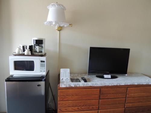 a microwave and a computer on top of a refrigerator at Sundown Inn of Morro Bay in Morro Bay