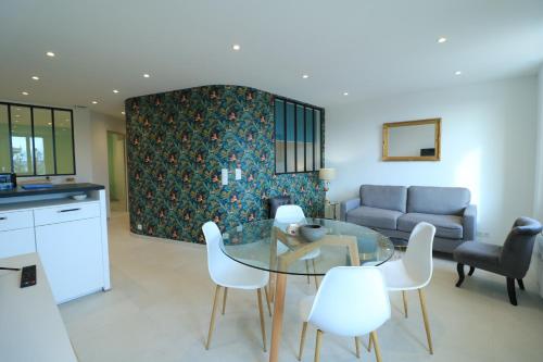 - un salon avec une table en verre et des chaises blanches dans l'établissement LUMINEUX 3 PIECES RENOVE FACE AU PORT l! A2B218, à Cannes