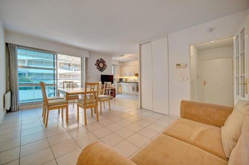 un salon avec un canapé, une table et des chaises dans l'établissement MODERNE 3 PIECES CANNES CENTRE AVEC BALCON l! A2B67, à Cannes