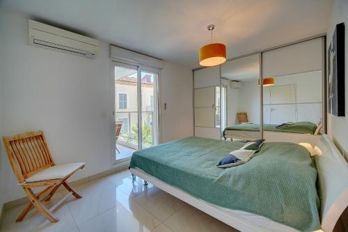 une chambre avec deux lits et une chaise et une fenêtre dans l'établissement 2 PIECES MODERNE AVEC TERRASSE ET PARKING A 3MN DES PLAGES !l- A1B230, à Cannes
