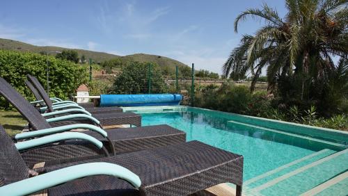 a group of chairs sitting next to a swimming pool at Casona Granado in El Pilar y Provincias