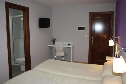 a bedroom with a bed and a toilet and a desk at Verona in Granada
