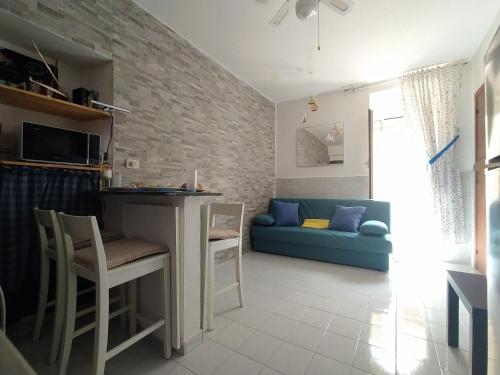 un soggiorno con divano blu e tavolo di Via Marina 19 - Casa sul mare. a Buggerru