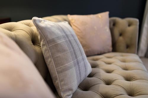 a couch with two pillows on top of it at Duke Of Marlborough in Woodstock