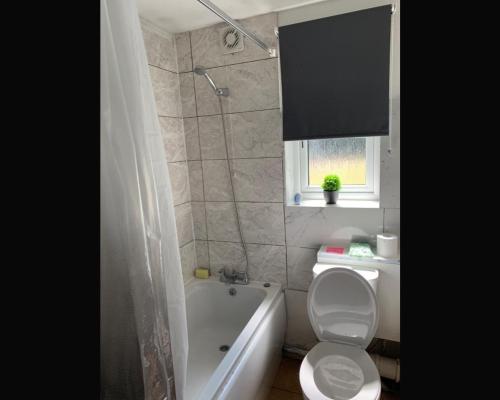 a bathroom with a toilet and a tub and a sink at Stunning 1 bedroom apartment in Dagenham in Dagenham