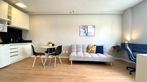uma sala de estar com um sofá e uma mesa em QSA - Anora Spaces - Metropolis Alphaville em Barueri