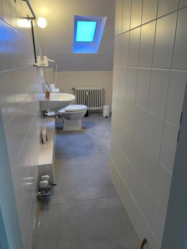 baño con lavabo y aseo y ventana en Appartement 5 Willingen, en Willingen