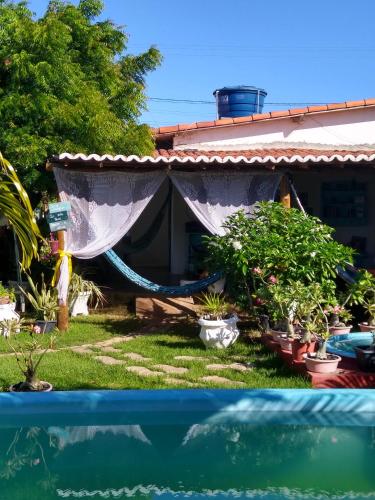 a house with a hammock in the yard at Pousada São Miguel Filosofal in São Miguel do Gostoso