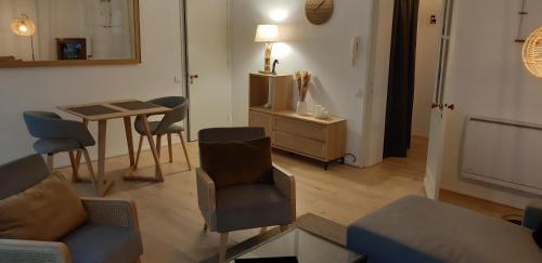 un salon avec un canapé, des chaises et une table dans l'établissement Burdigala Homes - Appart de Saige, à Bordeaux