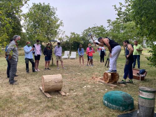 a group of people standing around a man playing with wood at Casa Rural Ulle Gorri in Unzá
