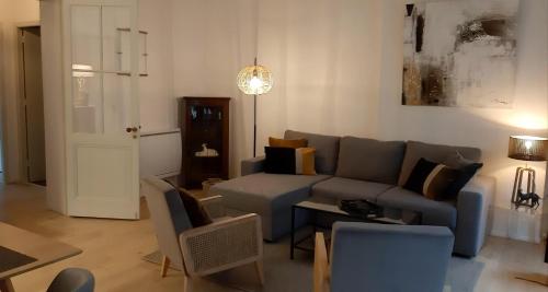 un salon avec un canapé et une table dans l'établissement Burdigala Homes - Appart de Saige, à Bordeaux