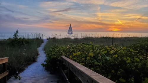 un velero en el agua con un camino que conduce a la playa en Casey Key Resort - Gulf Shores, en Venice