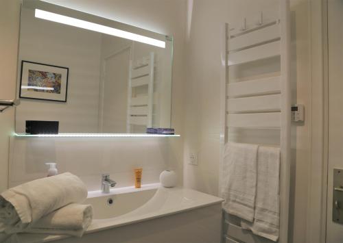 une salle de bain blanche avec un lavabo et un miroir dans l'établissement ROOFTOP CROISETTE/ALEXANDRE III, à Cannes