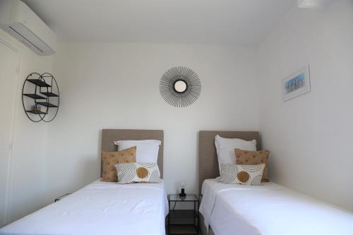 deux lits dans une chambre aux murs blancs dans l'établissement ROOFTOP CROISETTE/ALEXANDRE III, à Cannes