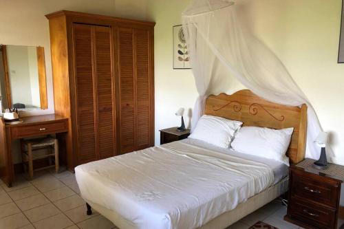 a bedroom with a white bed with a wooden headboard at Delightful 4bed modern villa with WiFI in Gros Islet