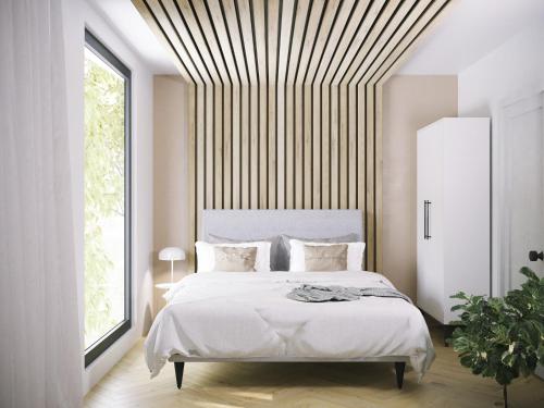 a bedroom with a white bed with a striped ceiling at LoveSea apartments Rewal in Rewal