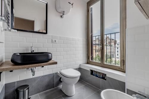 een badkamer met een wastafel, een toilet en een raam bij Roma House Piramide in Rome