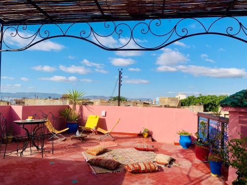 a living area with a couch, a table, and a tv at Riad Zahraa Al Ismailia in Meknès