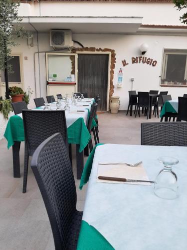 a row of tables and chairs with green napkins at Osteria B&B Il Rifugio in Peschici