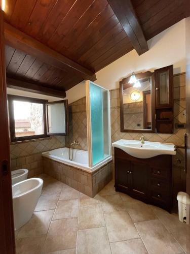 a bathroom with a tub and a sink and a bath tub at La Vie En Rose in Fondi