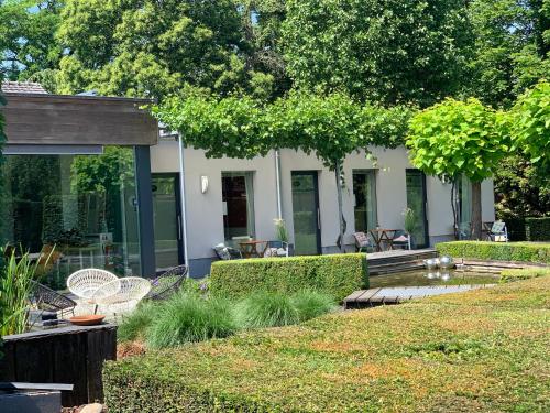 ハレにあるB&B Gustoの背景の家屋と椅子のある庭園