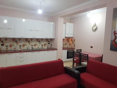 een woonkamer met 2 rode banken en een keuken bij Seaside Apartment with two bedrooms in Vlorë