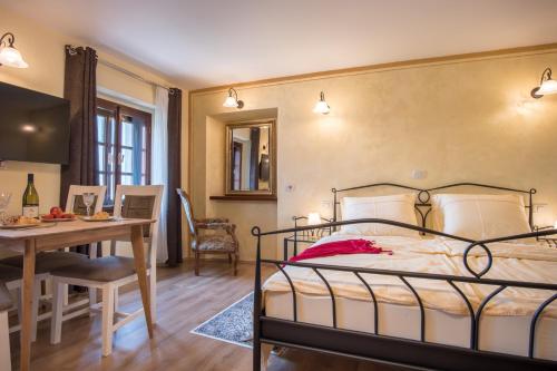 1 dormitorio con cama, mesa y comedor en Vila Radolca apartments & rooms, en Radovljica