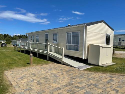 Seton sands holiday park - Premium caravan - 2 bedroom sleeps 4 في Port Seton: منزل متنقل مع منحدر ومنزل