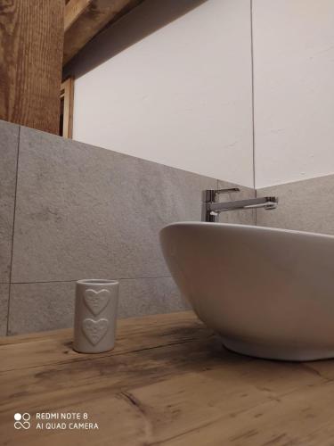 a bathroom with a sink and a cup on a counter at BeB LUCA76 in Avise