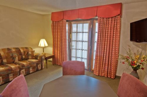 a living room with a couch and a table at MCM Elegante Suites Abilene in Abilene
