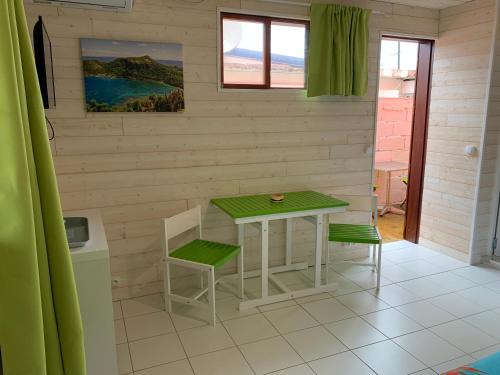 a small table and two chairs in a room at Les Lianes De Mysore in Deshaies