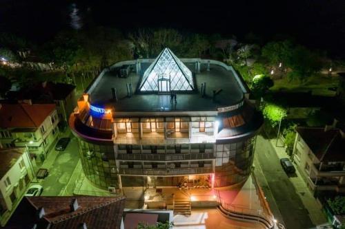 un grand bâtiment avec un toit éclairé la nuit dans l'établissement The LODGE Hotel, à Tsarévo