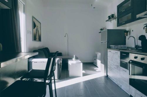Deluxe Apartment by Prima Lodging في سلانيك: مطبخ مع كرسيين وطاولة ومغسلة