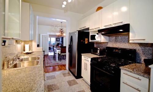 een keuken met een zwarte koelkast en een wastafel bij Refuge in the Heart of Montrose in Houston
