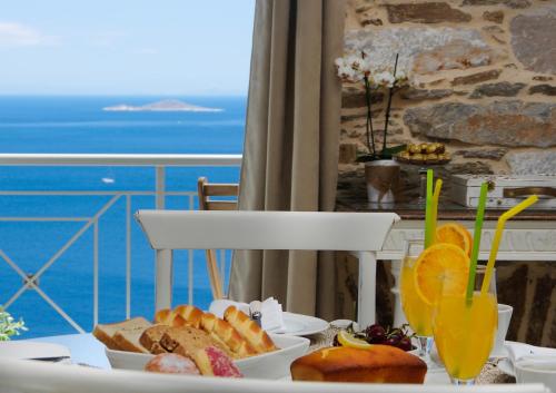 a table with a plate of food and a view of the ocean at TOP SUITES in Ermoupoli