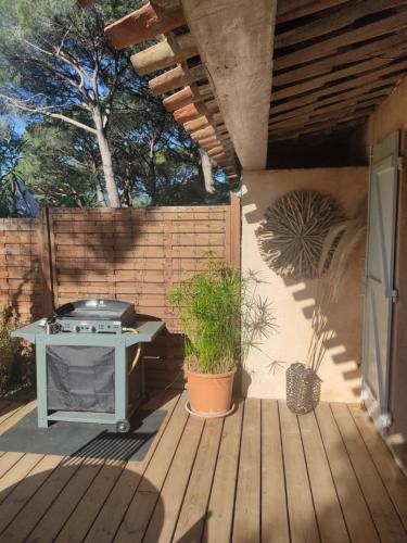 une terrasse en bois avec un barbecue dans l'établissement Joli mazet clim vue St Tropez, à Sainte-Maxime