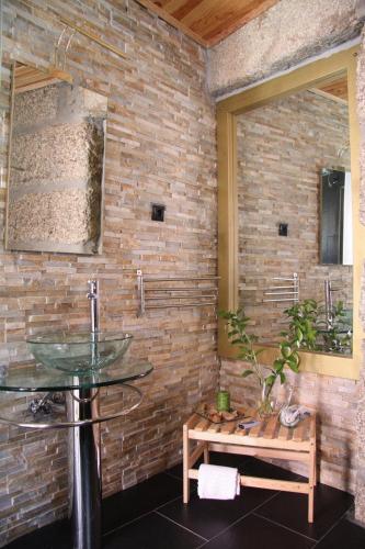 a bathroom with a sink and a brick wall at SEIA Alojamento D Ines in Seia