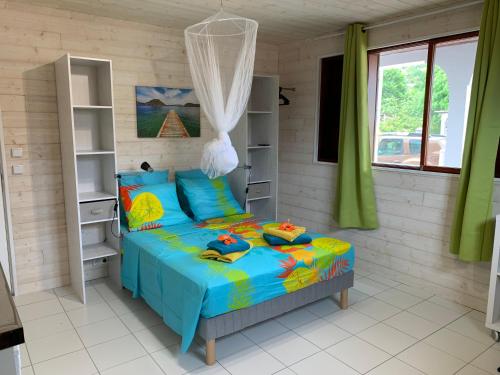1 dormitorio con 1 cama en una habitación con cortinas verdes en Les Lianes De Mysore en Deshaies